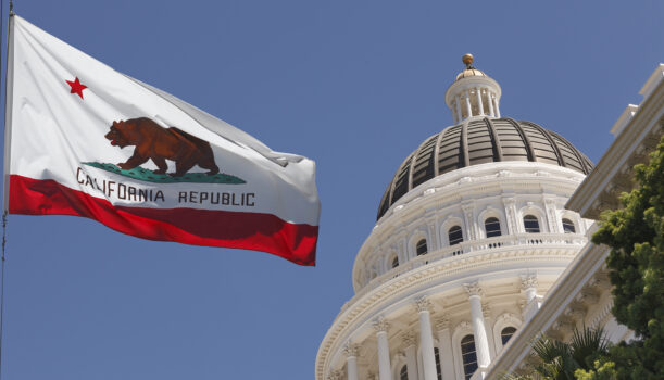 Image of California State Capitol with California flag in view