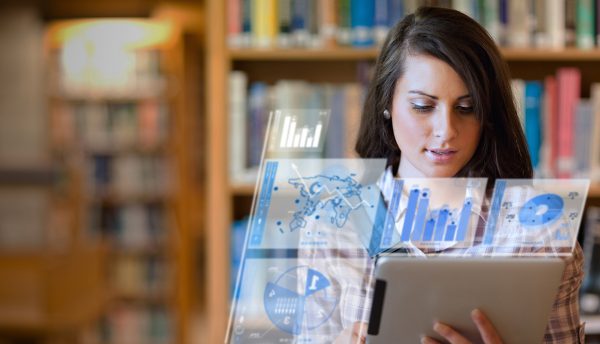 Image of student working on her futuristic tablet in a library
