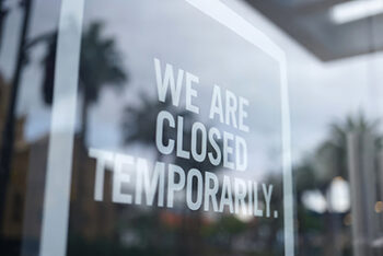 Glass door of a business. Sign on front says "WE ARE CLOSED TEMPORARILY"