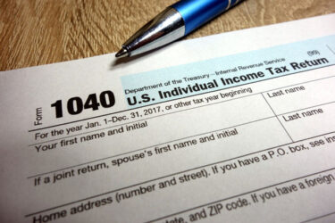 US tax form 1040 and pen on wooden table