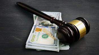 Gavel and money in the court. Penalty or bribe.