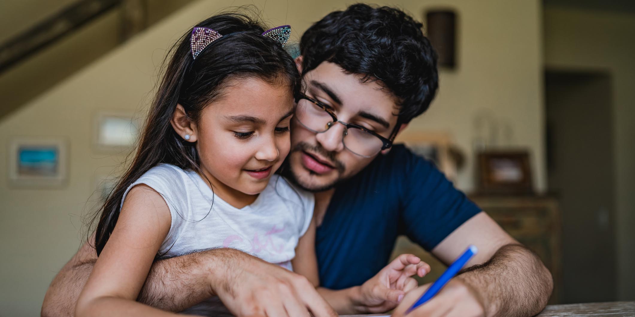 Man signing papers with daughter in his lap