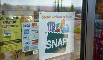 "SNAP welcomed here" sign is seen at the entrance to a grocery store.
