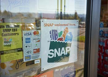 "SNAP welcomed here" sign is seen at the entrance to a grocery store.