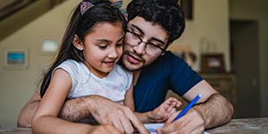 Man signing papers with daughter in his lap