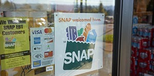 "SNAP welcomed here" sign is seen at the entrance of a store.