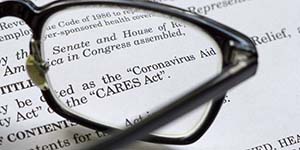Pair of eyeglasses is zooming in on the text of the CARES Act federal legislation